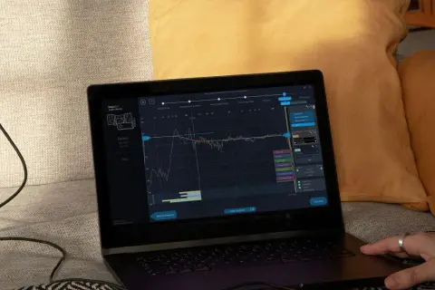 Na ekranie laptopa widoczny jest wykres kalibracji dźwięku, prawdopodobnie z użyciem systemu yamaha ypao.