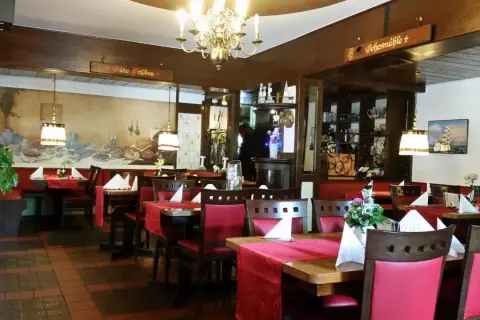 Gemütliche Stuben mit roten Tischdecken und Holzschnitzereien laden zum Verweilen ein. Hier finden Sie einige der besten Restaurants in Bergisch Gladbach.