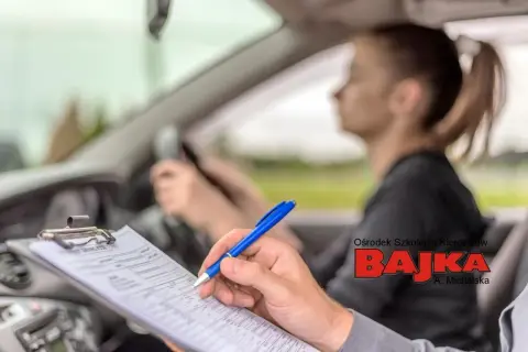 Instruktor notuje postępy kursantki. Skuteczne sposoby na stres przed egzaminem na prawo jazdy to m.in. dobra nauka i wsparcie.