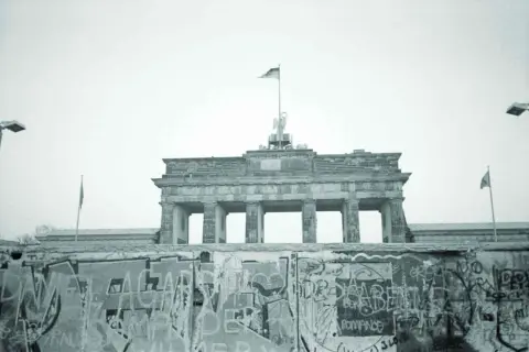 Brama Brandenburska nad murem berlińskim, symbolem podziału miasta od momentu, kiedy wybudowano mur berliński.