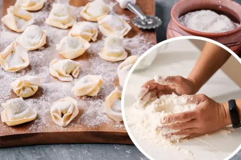Ręce mieszają mąkę, przygotowując ciasto na pierogi. Na desce leżą gotowe pierożki, posypane mąką.