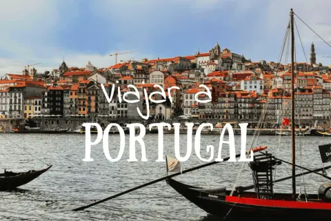 Barcos tradicionales navegan por el río Duero ante la colorida Ribeira de Oporto. ¡Descubre qué hacer en Portugal!