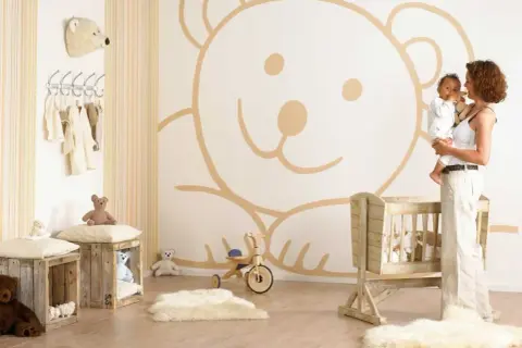 Cameretta neonato maschio con orso gigante disegnato sul muro, culla in legno e peluche. Idee pareti cameretta neonato maschio.