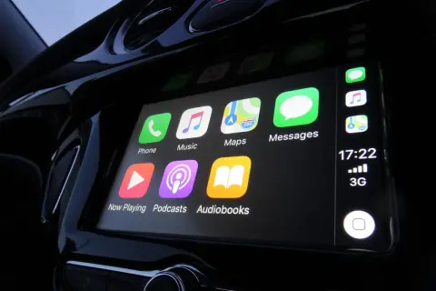 Ekran samochodu z ikonami Apple CarPlay: Telefon, Muzyka, Mapy, Wiadomości, Teraz odtwarzane, Podcasty, Audiobooki.