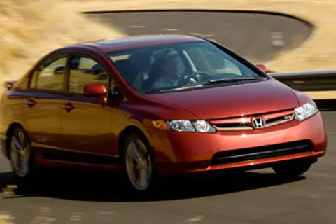 Czerwony Honda Civic Si zgrabnie pokonuje zakręt na pustynnej drodze.