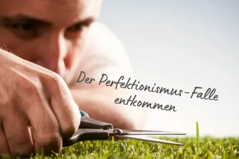 Mann schneidet mit Schere ein einzelnes Grashalm. Die Psychologie des Perfektionismus zeigt sich in diesem Detail.