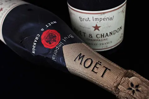 Dwie butelki szampana Moët & Chandon Brut Impérial na czarnym tle. Zastanawiasz się, ile szampan ma procent? Zwykle 12%.