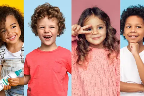 Niños sonriendo, uno con un corte pelo chico rizado y otro con un producto para el cabello.