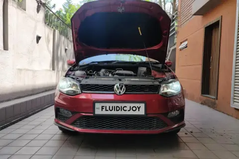 Czerwony VW Polo z otwartą maską, gotowy do wymiany żarówki H7.