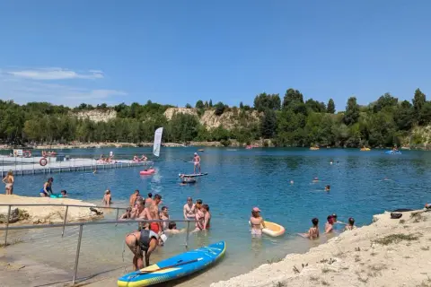 Ludzie kąpią się i pływają na deskach SUP w słoneczny dzień nad zalewem Balaton Trzebinia.