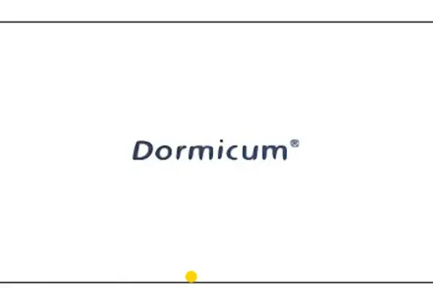 Niebieski napis "Dormicum" na białym tle, z żółtą kropką na dole.