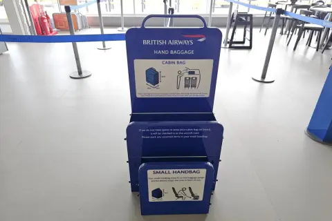 Niebieska miarka bagażu podręcznego British Airways na lotnisku. Sprawdź, czy Twój bagaż podręczny zmieści się w wyznaczonych wymiarach.