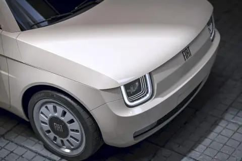 Nowy Fiat 126p w beżowym kolorze, z nowoczesnymi światłami LED i charakterystycznym logo FIAT na masce.