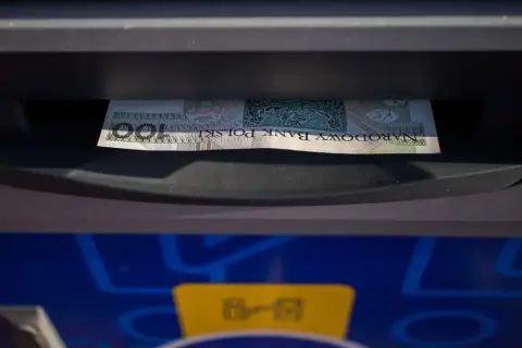 Jednorazowa wpłata gotówki do bankomatu. Banknot 100 zł wchodzi do szczeliny.