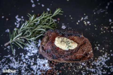 Perfekt medium gegrilltes Steak mit Kräuterbutter, Rosmarin und grobem Salz.