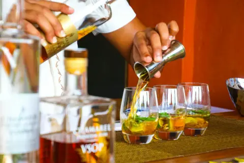 Barman nalewa rum VSOP do szklanek. Czysta wódka ma zazwyczaj 40% alkoholu, ale ten rum jest wyjątkowy.