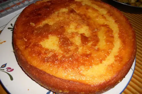 Un délicieux cake à l'orange, doré et moelleux, prêt à être dégusté. Sa croûte caramélisée promet une explosion de saveurs.