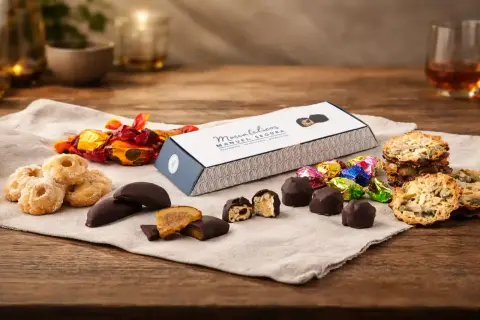 Deliciosos dulces de Aragón: bombones, galletas y caramelos envueltos en papel brillante, junto a una caja de "Moscatelicos" de Manuel Segura.