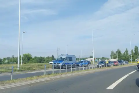 Korki w Toruniu. Policja kieruje ruchem na zakorkowanej drodze.