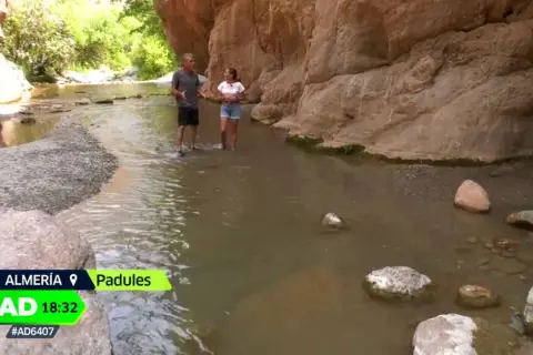 Dos personas caminan por un río en un cañón, explorando qué ver en Padules, Almería.