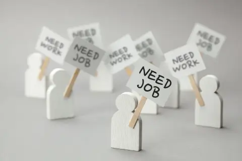Figurki ludzi z transparentami "NEED JOB" i "NEED WORK". Dowiedz się, jak sprawdzić status bezrobotnego online.