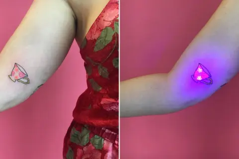 Uroczy tatuaż filiżanki z kwiatami, który pod wpływem światła UV staje się magicznym, fluorescencyjnym dziełem sztuki.