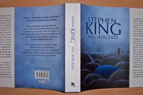 Okładka książki Stephen King Pan Mercedes. Mroczna ilustracja z parasolami i sygnalizacją świetlną.