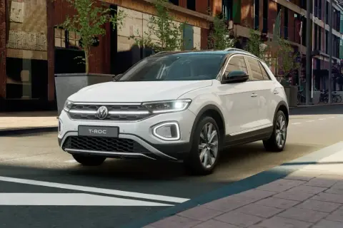 Biały Volkswagen T-Roc stoi na ulicy miejskiej, gotowy na kolejną przygodę.