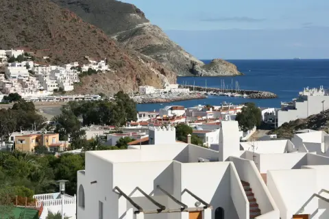 Vista de la bahía de San José, con sus casas blancas y el puerto deportivo. El paisaje de **4 nudos cabo de gata** se extiende hasta el mar azul.