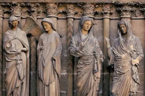 Kamienne rzeźby przedstawiające postacie biblijne, w tym anioła i kobiety w welonach, przypominające różne **ikony Matki Boskiej rodzaje**.