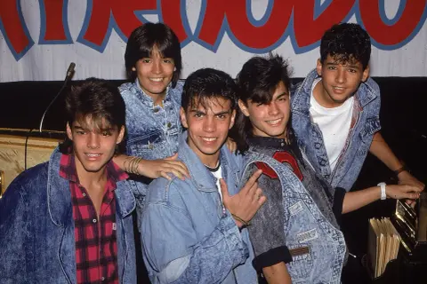 Fünf junge Männer in Jeansjacken, die wie eine Boygroup posieren.