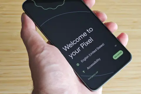 Mano sujetando un Pixel listo para configurar mi dispositivo Android. Pantalla de bienvenida en inglés, con opciones de accesibilidad y llamada de emergencia.