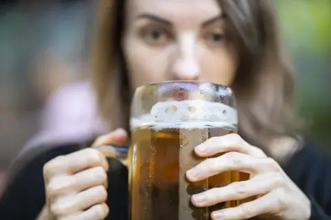Kobieta pije piwo z dużego kufla. Zastanawiasz się, ile kalorii ma piwo smakowe?