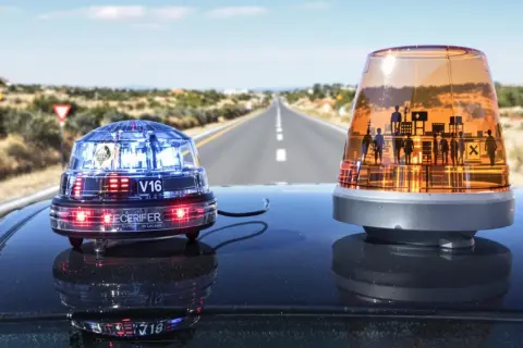 Deux gyrophares sur le toit d'une voiture, sur une route déserte. L'un est bleu et rouge, l'autre orange avec des silhouettes. Indispensable équipement obligatoire voiture Espagne pour la sécurité.