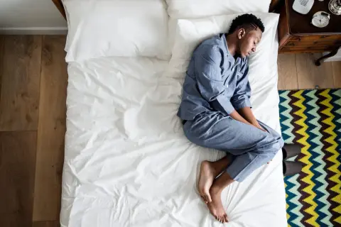 A man sleeps on his side, curled up. What does the way you sleep say about you?