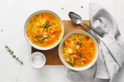Dwie miseczki aromatycznej zupy mocy, pełnej warzyw i makaronu, gotowe do podania.
