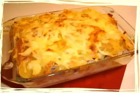 Un plat gratiné de parmentier de cabillaud, avec une couche dorée de fromage fondu, prêt à être dégusté.