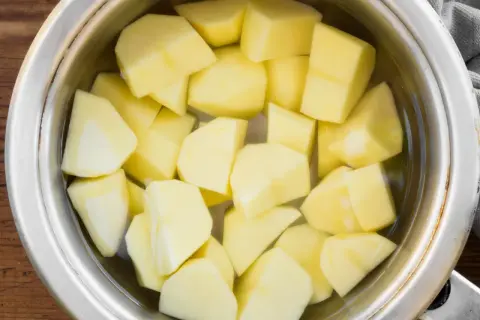 Pokrojone ziemniaki w garnku z wodą, gotowe do ugotowania. To pierwszy krok, jak ugotować ziemniaki na obiad.