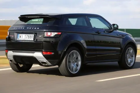 Czarny Land Rover Evoque jedzie po drodze, widać jego tylną część i obręcz koła w ruchu.