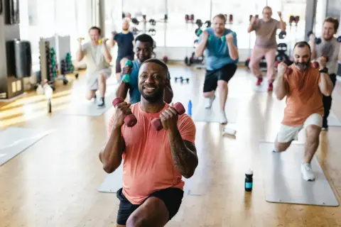 Männer trainieren mit Hanteln im Fitnessstudio. Ob es reicht, eine Muskelgruppe einmal pro Woche zu trainieren, ist eine Frage der Ziele.
