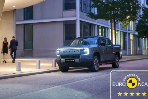 Elegancka para idzie obok nowoczesnego, elektrycznego pickupa Maxus eTerron9. Auto zdobyło 5 gwiazdek w testach Euro NCAP.