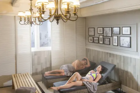 Para relaksuje się na leżakach w spa, przykryci ręcznikami.