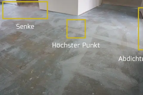 Der Boden wird vorbereitet, um die Ausgleichsmasse zu versiegeln. Markierungen zeigen Senken, den höchsten Punkt und die Abdichtung.