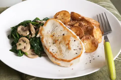Smażony filet z indyka z pieczonymi ziemniakami i szpinakiem z pieczarkami. Idealne danie, gdy zastanawiasz się, co zrobić z fileta z indyka na szybko.