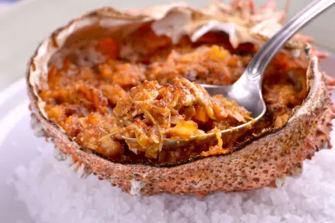 Txangurro a la donostiarra, un delicioso relleno de marisco en su caparazón, listo para ser degustado con una cuchara.