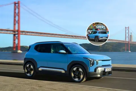 El ev2 Kia azul, con un diseño moderno, cruza un puente icónico. En un círculo, se ve su parte trasera con grafitis.