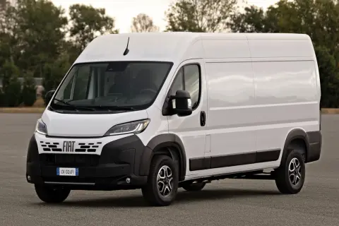 Biały Fiat Ducato Maxi, gotowy do transportu towarów, stoi na tle drzew.