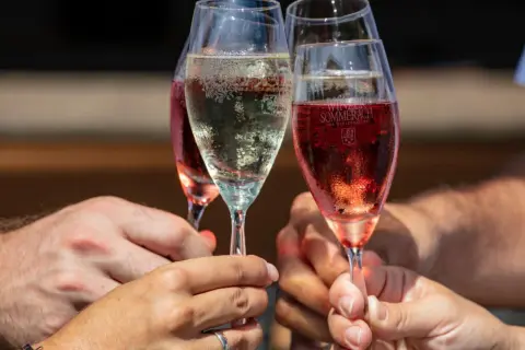 Brindisi con bollicine dorate e rosate, il champagne significato di festa e gioia.