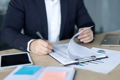 Biznesmen analizuje dokumenty, zastanawiając się, wadium co to jest i jak wpływa na transakcję.