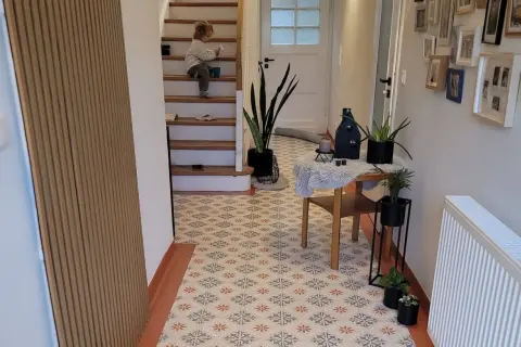 Un enfant sur les escaliers, un sol aux motifs floraux. Avis sur la peinture sur carrelage : un rendu chaleureux et moderne.